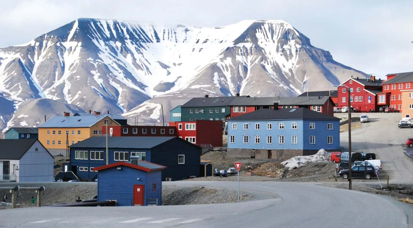 Coloured wooden houses of Longyearbyen below the snow-streaked flank of Hiorthfjellet