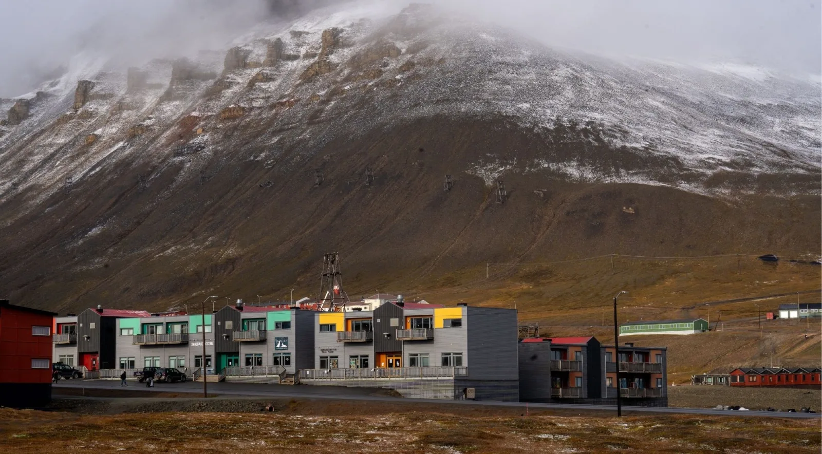 Longyearbyen's main street shops below a mist-covered mountain in autumn