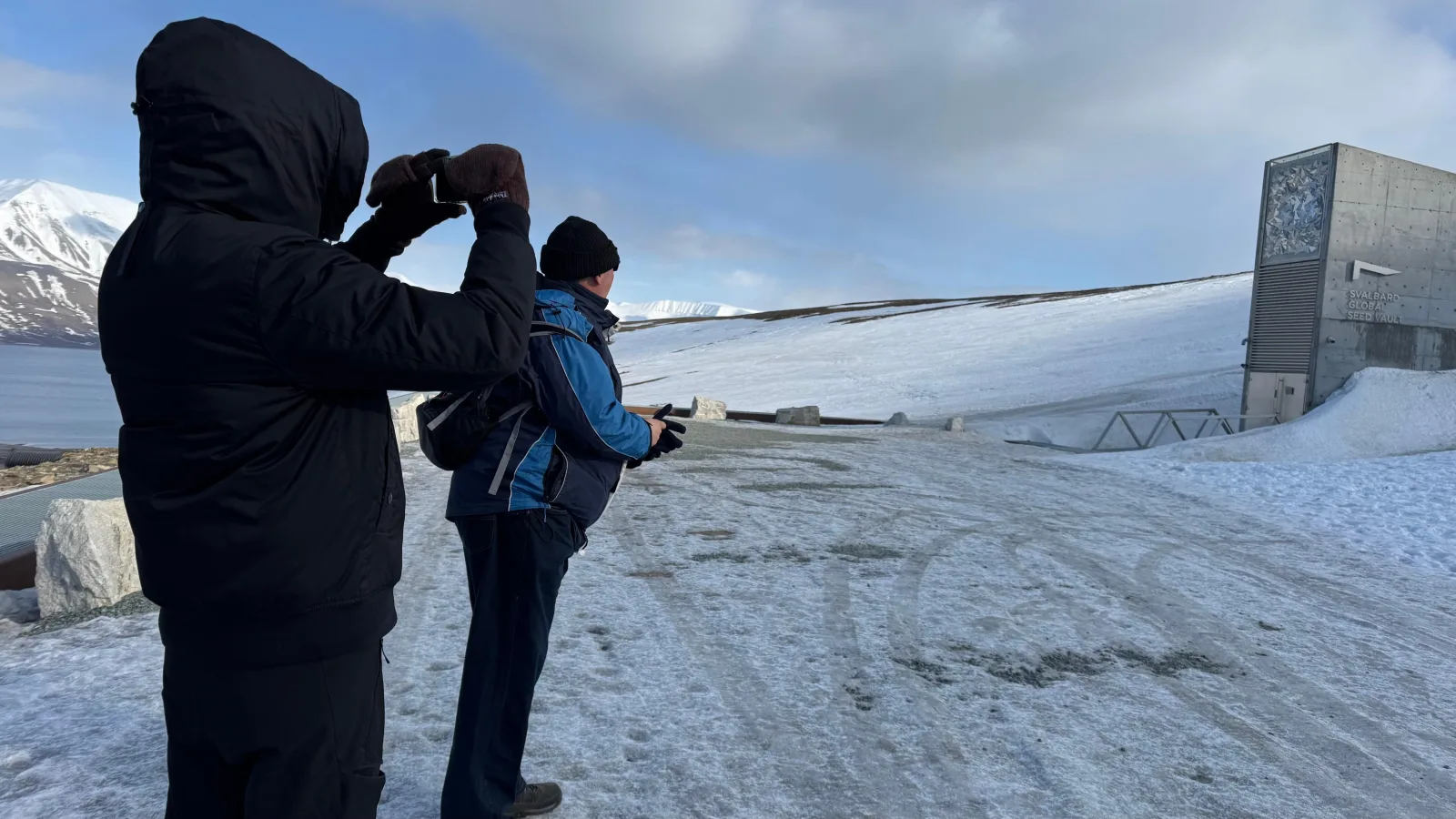 Visitors photographing the Seed Vault entrance from the snow-covered access road