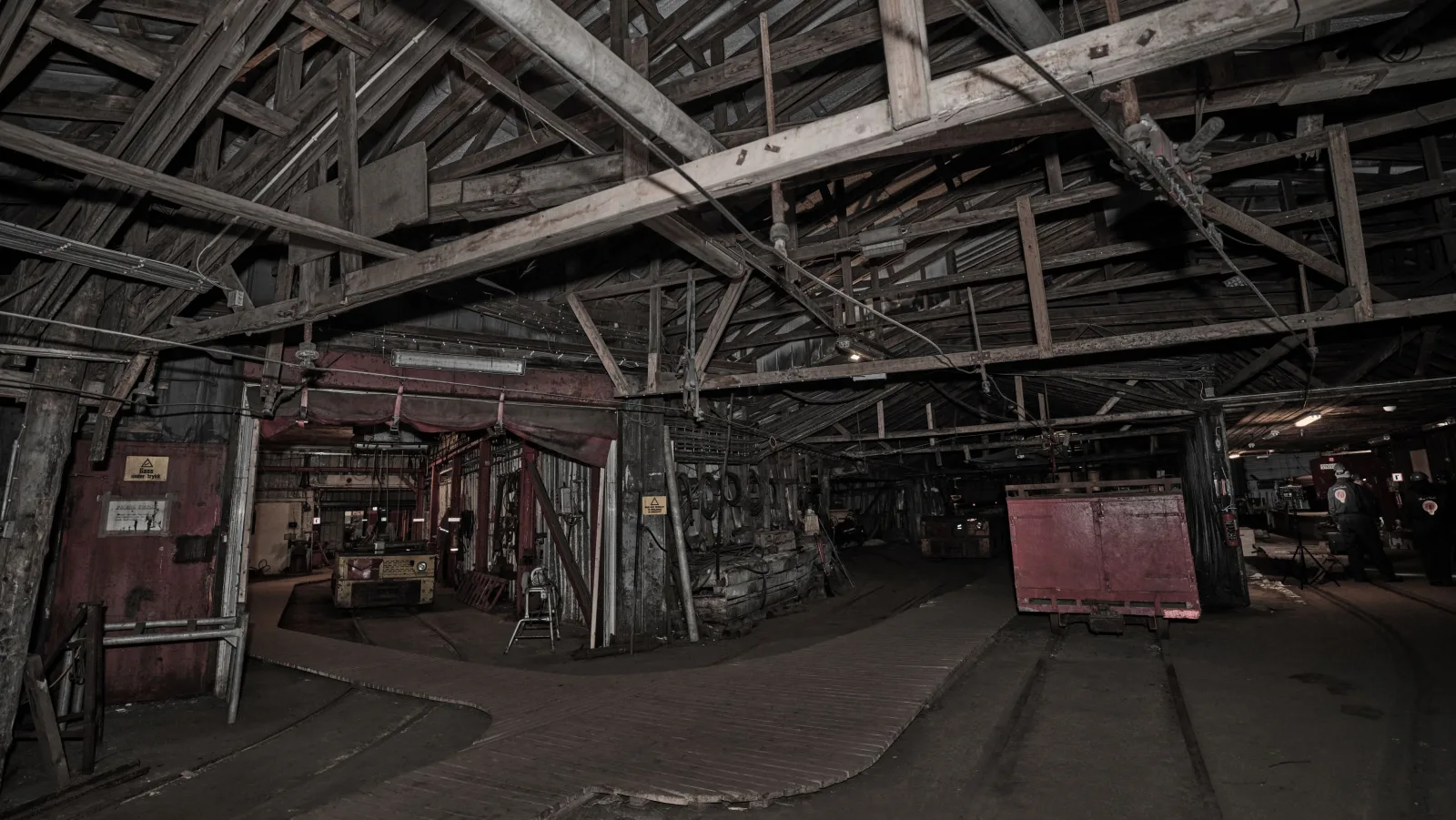 Timber-framed workshop hall inside Mine 3, machinery and a coal wagon left in place since 1996