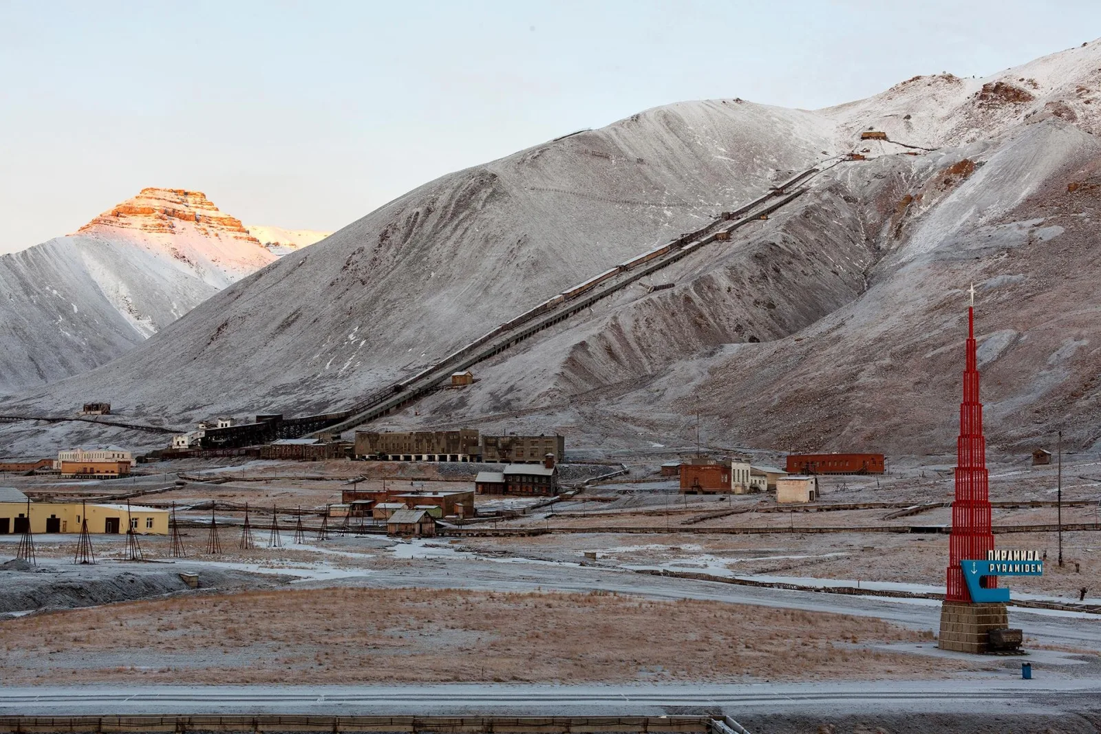 Pyramiden under first snow, the coal conveyor running down the mountain to the settlement